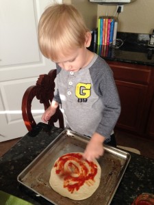 Making his own personal pizza :)